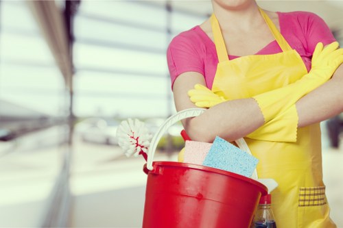 Professional cleaner maintaining desks and meeting rooms in an E1 office